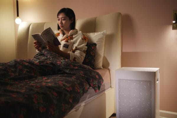 sa600 air purifier sitting next to the bed