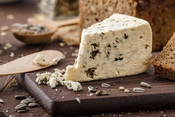 a blue cheese on a wooden cuttin board