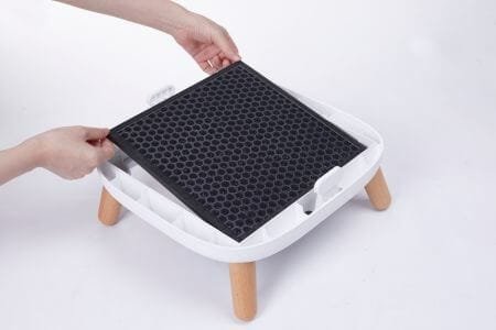 a person inserting a carbon filter into an air purifier