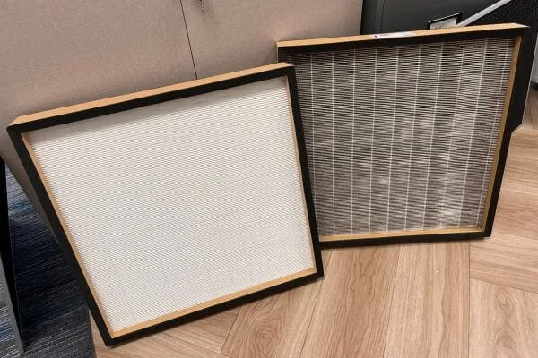 a clean white hepa filter next to a dirty hepa filter